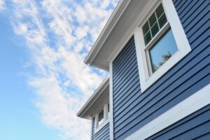 An upward looking view of a home with navy-blue siding. 